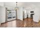 Dining area features refinished hardwood floors adjacent to a modern kitchen with stainless steel appliances at 8510 Castle Pine Ct, Charlotte, NC 28226