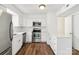 Renovated kitchen features stainless steel appliances, white cabinets, and wood flooring at 8510 Castle Pine Ct, Charlotte, NC 28226