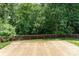 A backyard with a large patio, beautiful green trees, and a brown wooden fence at 8524 Emerald Fern Way, Charlotte, NC 28214