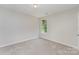 A carpeted bedroom with bright, neutral paint and a window overlooking lush, green trees at 8524 Emerald Fern Way, Charlotte, NC 28214
