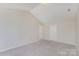 A carpeted bedroom features bright, neutral paint, vaulted ceilings, and has two large, white doors at 8524 Emerald Fern Way, Charlotte, NC 28214