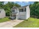 Side view of a two-story home featuring vinyl siding and an attached garage, surrounded by lush greenery at 8524 Emerald Fern Way, Charlotte, NC 28214