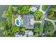 Aerial view of the home featuring a swimming pool, patio, mature landscaping, and a circular driveway at 8721 Lake Challis Ln, Charlotte, NC 28226
