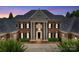 Majestic brick home boasts grand columns, classic shutters, and an inviting entrance at 8721 Lake Challis Ln, Charlotte, NC 28226