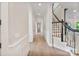 Long hallway features hardwood floors, wainscoting, and staircase with dark trim at 8721 Lake Challis Ln, Charlotte, NC 28226