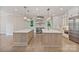 Gourmet kitchen featuring double islands, professional appliances, custom cabinetry, and hardwood floors at 8721 Lake Challis Ln, Charlotte, NC 28226