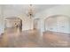 Spacious living room features an open layout, hardwood floors, archways, and elegant chandelier at 8721 Lake Challis Ln, Charlotte, NC 28226