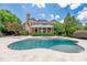 A luxurious backyard features a large pool with a spa and travertine tile, perfect for outdoor relaxation at 8721 Lake Challis Ln, Charlotte, NC 28226