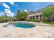 Beautiful backyard pool area features travertine tile, a spa, and lush landscaping creating a private retreat at 8721 Lake Challis Ln, Charlotte, NC 28226