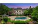 Stunning brick home features a beautiful pool, patio, gazebo, and lush landscaping at 8721 Lake Challis Ln, Charlotte, NC 28226