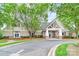Inviting clubhouse featuring an entrance portico, with a well-maintained landscape, and ample parking at 9641 Bellamy Nw Pl, Concord, NC 28027