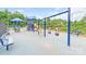 Community playground featuring swings, slides, and covered play areas, surrounded by lush greenery at 9641 Bellamy Nw Pl, Concord, NC 28027