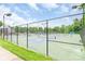 Community tennis courts with well-maintained nets and surfaces, surrounded by trees and fencing at 9641 Bellamy Nw Pl, Concord, NC 28027