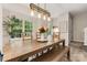 Bright dining room features a large wooden table, a bench, and large windows with backyard views at 9651 Bailey Rd, Cornelius, NC 28031