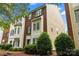 A view of a two story townhome with brick accents and manicured landscaping at 9651 Bailey Rd, Cornelius, NC 28031
