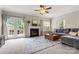 Spacious living room with fireplace, ceiling fan, gray sofa, and access to the outdoor deck at 9651 Bailey Rd, Cornelius, NC 28031