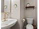 Charming powder room features a white pedestal sink and gold fixtures at 9651 Bailey Rd, Cornelius, NC 28031