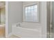 Bathroom featuring a soaking tub next to a glass enclosed shower and a window for natural light at 105 Stumpy Creek Rd, Mooresville, NC 28117