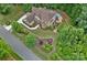 Aerial view of a home showcasing well-manicured landscaping, a pool area, a putting green, and surrounding lush greenery at 117 Walking Horse Trl, Davidson, NC 28036