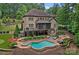 Expansive backyard featuring a pool, spa, outdoor seating, and lush landscaping at 117 Walking Horse Trl, Davidson, NC 28036