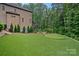 Spacious backyard with a putting green, lush trees, and a manicured lawn, perfect for outdoor activities at 117 Walking Horse Trl, Davidson, NC 28036