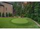 Expansive backyard featuring a putting green, access stairs, lush trees, and patio with outdoor seating at 117 Walking Horse Trl, Davidson, NC 28036