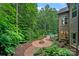 Serene backyard featuring a stone fire pit, lush greenery, winding pathways, and a glimpse of the pool area at 117 Walking Horse Trl, Davidson, NC 28036