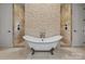 Luxurious bathroom featuring a standalone tub, stone walls, and separate shower stalls at 117 Walking Horse Trl, Davidson, NC 28036