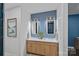 Modern bathroom featuring dual sinks, wood accents, and stylish mirror lighting at 117 Walking Horse Trl, Davidson, NC 28036