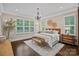 Light-filled bedroom with chandelier, decorative baskets and large windows overlooking backyard at 117 Walking Horse Trl, Davidson, NC 28036