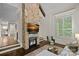 Cozy living room with a stone fireplace, hardwood floors, and plantation shutters at 117 Walking Horse Trl, Davidson, NC 28036