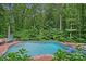 Landscaped swimming pool surrounded by lush greenery, perfect for relaxation and recreation at 117 Walking Horse Trl, Davidson, NC 28036