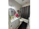 Well-lit bathroom featuring a vanity sink, a round mirror, and a shower-tub combination with a curtain at 13219 Asbury Chapel Rd, Huntersville, NC 28078