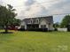 Traditional home with a well-maintained lawn and landscaped front yard, offering a serene curb appeal at 13219 Asbury Chapel Rd, Huntersville, NC 28078