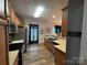 Bright kitchen with stainless steel appliances, dark-trimmed windows, and wood-style flooring at 13219 Asbury Chapel Rd, Huntersville, NC 28078