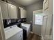 Functional laundry room featuring a washer, dryer, and upper cabinets, offering convenience and organization at 13219 Asbury Chapel Rd, Huntersville, NC 28078