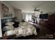 Bright main bedroom features a king bed, ceiling fan, and sitting area with a sofa perfect for relaxation at 13219 Asbury Chapel Rd, Huntersville, NC 28078