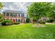 A traditional brick home with a well-manicured lawn and a vibrant red front door at 1522 12Th Fairway Nw Dr, Concord, NC 28027