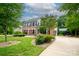 Charming brick home with a well-kept lawn, mature trees, and a welcoming red front door at 1522 12Th Fairway Nw Dr, Concord, NC 28027