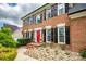 Attractive brick home with black shutters and a bright red door, framed by lush landscaping at 1522 12Th Fairway Nw Dr, Concord, NC 28027