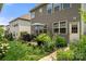 Well-maintained backyard featuring patio with umbrella, grill, lush plants and landscaping at 15515 Laverack Ln, Davidson, NC 28036