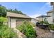 Private backyard patio with a dining area, lush landscaping, and a detached garage at 15515 Laverack Ln, Davidson, NC 28036