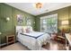 Stylish bedroom with green walls, hardwood floors, framed art, and natural light at 15515 Laverack Ln, Davidson, NC 28036