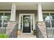 Inviting entryway featuring a decorative wreath, stone accents, and stylish railings at 15515 Laverack Ln, Davidson, NC 28036