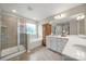 Bright main bathroom featuring double vanity, soaking tub, and glass shower at 15515 Laverack Ln, Davidson, NC 28036