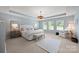 Spacious main bedroom with tray ceiling, neutral carpet, light blue walls, and decorative chandelier at 15515 Laverack Ln, Davidson, NC 28036
