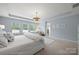 Bright and airy main bedroom featuring plush carpeting, white furniture, and ample natural light at 15515 Laverack Ln, Davidson, NC 28036