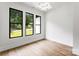 Bright bedroom featuring wood floors, white walls, black frame windows with tree lined view at 1626 Burtonwood Cir, Charlotte, NC 28212