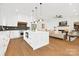 Open concept kitchen with island, stainless steel appliances, and hardwood floors flowing into the living room at 1626 Burtonwood Cir, Charlotte, NC 28212