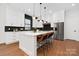 Open kitchen with stainless appliances, large island with seating, stylish backsplash, and modern pendant lighting at 1626 Burtonwood Cir, Charlotte, NC 28212